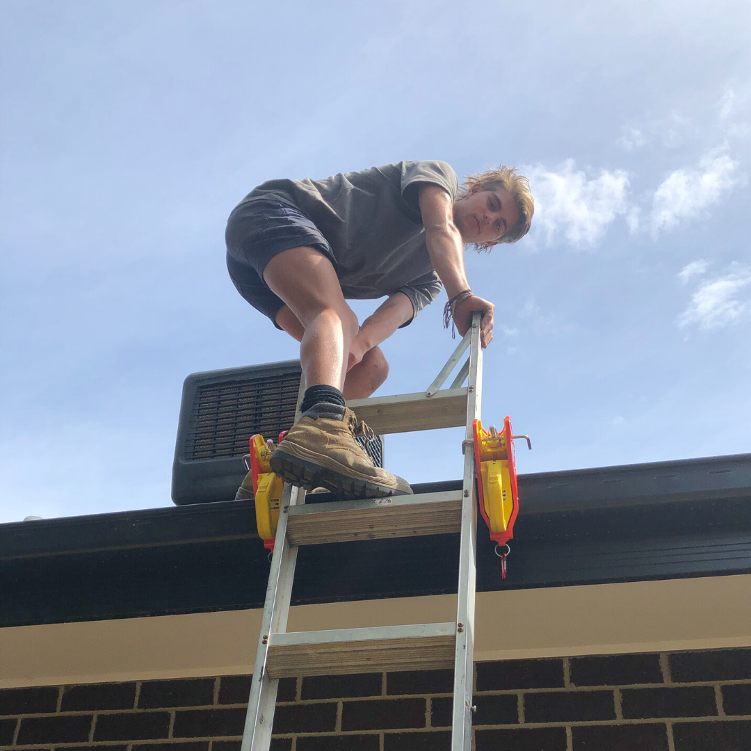 The man using silver ladder accessing the roof and using two ladder lock by lock jaw ladder grip